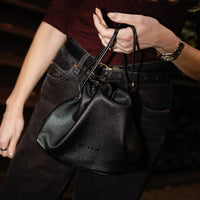 CMPLXN black drawstring bag carried
